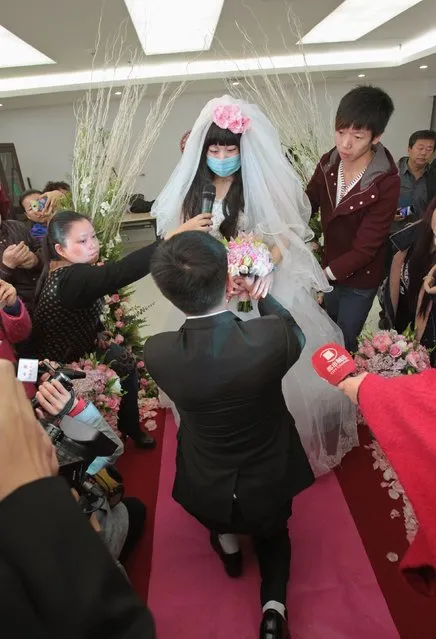 Newly-wed bride Fan Huixiang, a 25-year-old cancer patient, speaks to her groom Yu Haining (front) during their wedding at a hospital in Zhengzhou, Henan province, November 17, 2014. (Photo by Reuters/China Daily)