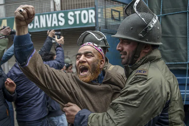 A supporter of All Parties Hurriyat Conference (APHC) shouts pro-freedom slogans as he is detained by police, during a protest on the death anniversary of separatist leader Maqbool Bhat in Srinagar, Indian controlled Kashmir, Sunday, February 11, 2018. Authorities imposed a curfew in some parts of Indian-controlled Kashmir's main city to prevent anti-Indian protests after separatist groups called a general strike demanding that Bhat's remains, interred in New Delhi's high security Tihar Jail, be returned for a proper burial. (Photo by Dar Yasin/AP Photo)