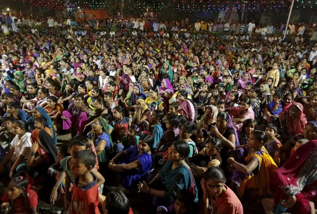 People sit on the ground as they watch the Ramlila performance, a re-enactment of the life of Hindu Lord Rama, ahead of Dussehra in Ahmedabad, India, October 19, 2015. Effigies of the 10-headed demon king "Ravana" are burnt on Dussehra, the Hindu festival that commemorates the triumph of Lord Rama over the Ravana, marking the victory of good over evil. Dussehra is celebrated on October 22. (Photo by Amit Dave/Reuters)