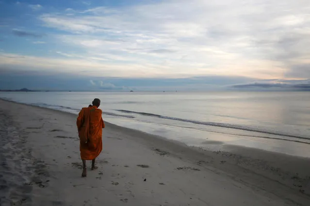 A Buddhist monk walks for alms offerings at a beach in Hua Hin, Thailand September 19, 2016. (Photo by Jorge Silva/Reuters)