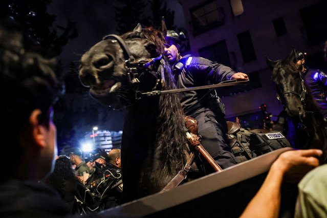 Police officers ride horses as people attend a protest against Israeli Prime Minister Benjamin Netanyahu's government and to call for the release of hostages kidnapped in the deadly October 7 attack on Israel by the Palestinian Islamist group Hamas, in Tel Aviv, Israel, on April 27, 2024. (Photo by Shannon Stapleton/Reuters)