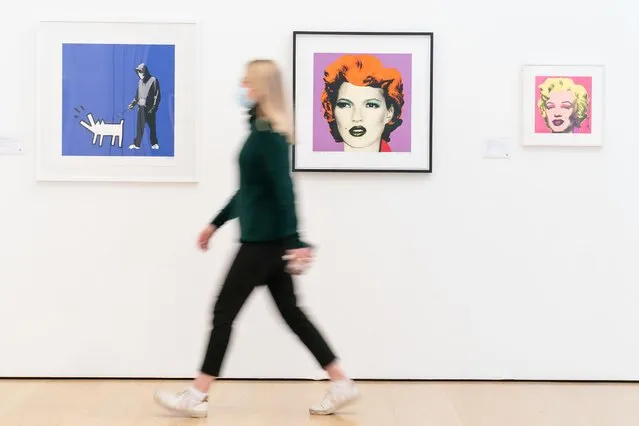 A visitor views a portrait of Kate Moss (centre) by Banksy on Wednesday, January 12, 2022, which is going on view to the public at Phillips auction house in central London until Thursday 19 January, ahead of its sale at auction with an estimate of 130,000 – 180,000 sterling. (Photo by Dominic Lipinski/PA Images via Getty Images)