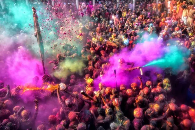 Hindu devotees throw colourful Gulal powder at each other at the Radharani temple in Mathura as part of a traditional ceremony during the Lathmar Holi festival on March 1, 2023. (Photo by Avishek Das/SOPA Images via ZUMA Press Wire/dpa)