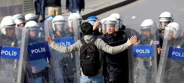 A demonstrator tries to stop riot police as they clash with a crowd gathering to commemorate last year's deadly suicide bombing near the main train station in Ankara, Turkey, October 10, 2016. (Photo by Umit Bektas/Reuters)