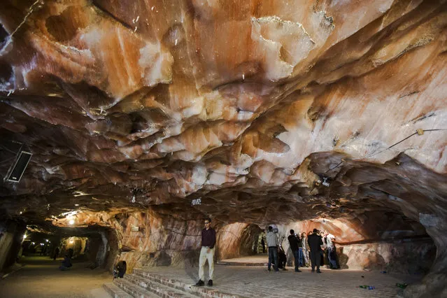 Visitors look at a cave in a salt mine, Khewra, Pakistan, December 13, 2014. Khewra Salt mines are the world's second and Pakistan's largest and oldest salt mine and a major tourist attaction, drawing up to 250,000 visitors a year and date back to 320 BCE. (Photo by Omer Saleem/EPA)