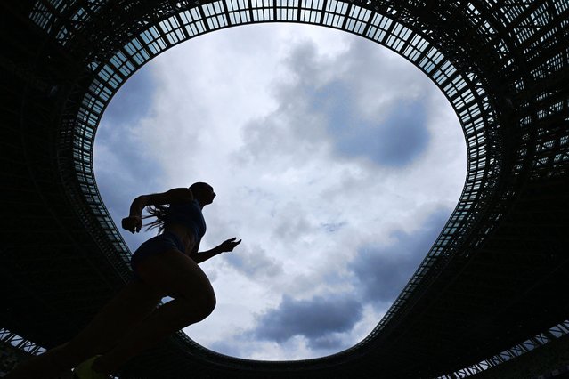 An athlete takes part in a warm-up around the track of the National Stadium in Tokyo on September 12, 2025, ahead of the World Athletics Championships. (Photo by Kirill Kudryavtsev/AFP Photo)