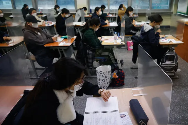 A student checks the time as others wait for the start of the annual college entrance examination amid the coronavirus pandemic at an exam hall in Seoul, South Korea, Thursday, December 3, 2020. South Korean officials are urging people to remain at home if possible and cancel gatherings as about half a million students prepare for a crucial national college exam. (Photo by Kim Hong-Ji/Pool Photo via AP Photo)