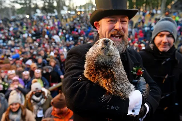 Groundhog handler A.J. Derume holds Punxsutawney Phil, who saw his shadow, predicting a late spring during the 136th annual Groundhog Day festivities on February 2, 2022 in Punxsutawney, Pennsylvania. Groundhog Day is a popular tradition in the United States and Canada. A crowd of upwards of 5000 people spent a night of revelry awaiting the sunrise and the groundhog's exit from his winter den. If Punxsutawney Phil sees his shadow he regards it as an omen of six more weeks of bad weather and returns to his den. Early spring arrives if he does not see his shadow, causing Phil to remain above ground. (Photo by Jeff Swensen/Getty Images)