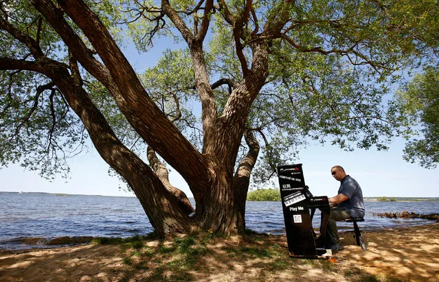 A man plays piano at a lake during the event “Free piano” on the outskirts of Minsk, Belarus May 5, 2018. (Photo by Vasily Fedosenko/Reuters)
