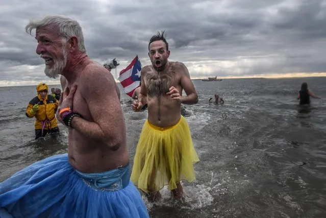People run into the Atlantic ocean during the annual Polar Bear plunge at Coney Island in New York, January 1, 2020. (Photo by Stephanie Keith/Reuters)