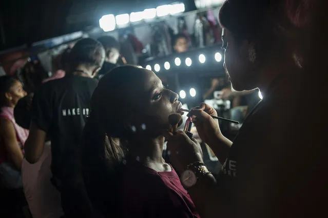 A model gets her make- up done prior to the Lagos Fashion & Design Week in Nigeria on October 26, 2016. The opening night attracted models, buyers, consumers and the media to view the latest creations by African designers, five of whom were showcasing plus-size collections in the Nigerian city. (Photo by Stefan Heunis/AFP Photo)