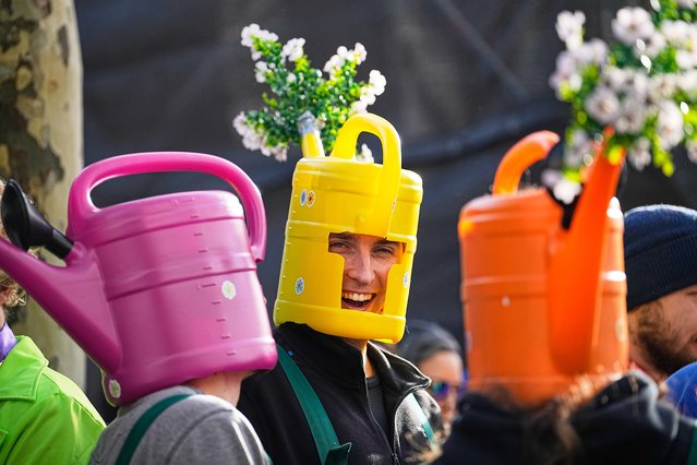 Costumed revelers wear watering cans on their heads in the central Heumarkt in Cologne, Germany, as thousands of carnival enthusiasts parade through the streets on Tuesday, November 11, 2025, officially opening the carnival season. (Photo by Martin Meissner/AP Photo)