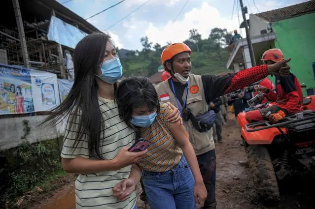 Relatives of victims react as a rescue worker asks them to leave an area hit by landslides in Sumedang regency, West Java province, Indonesia on January 11, 2021. (Photo by Raisan Al Farisi/Antara Foto via Reuters)