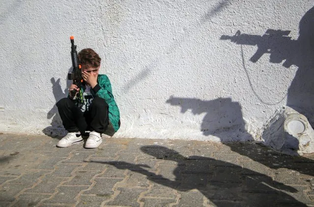 A Palestinian child plays with a gun in celebration of Eid al-Fitr, marking the end of Ramadan, in Jabalia refugee camp, in the northern Gaza Strip on April 22, 2023. (Photo by Mahmoud Issa/Quds Net News via ZUMA Press/Rex Features/Shutterstock)