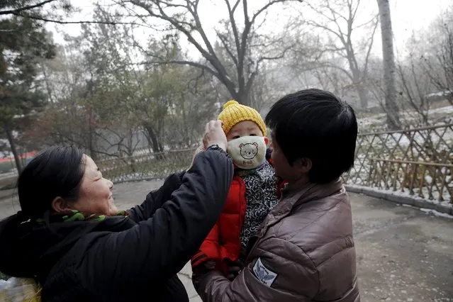 A woman fixes a protective mask on a baby during an extremely polluted day in Baoding, China November 30, 2015. (Photo by Damir Sagolj/Reuters)
