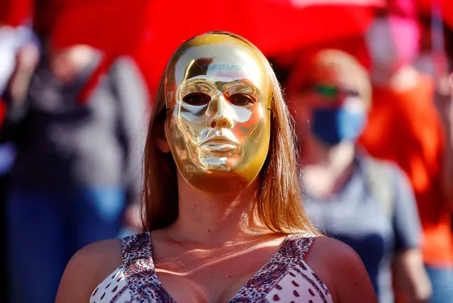 A woman wears a face mask as brothel workers protest against the lockdown of their business due to the coronavirus disease (COVID-19) outbreak, in front of Cologne's cathedral in Cologne, Germany, July 29, 2020. The sign on a mask reads: “Uprising”. (Photo by Wolfgang Rattay/Reuters)