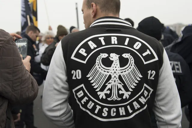 A demonstrator wears a jacket with the writing “Patriot Deutschland” (lt. Germany Patriot) during the fourth demonstration of the right-wing populist alliance “Wir fuer Deutschland” in Berlin, Germany, Saturday,  November 5, 2016. (Photo by Paul Zinken/DPA via AP Photo)