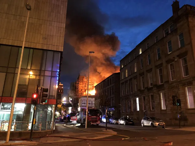 Flames and smoke rise from the Glasgow School of Art's Mackintosh Building in London, early Saturday, June 16, 2018. A large blaze ripped through the building at the Glasgow School of Art late Friday, the second time in four years that fire has damaged the famed Scottish school. (Photo by Douglas Barrie/PA Wire via AP Photo)
