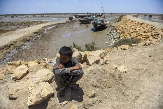 A boy waits to be evacuated to government relief camps before the due onset of cyclone, in Sujawal district, Sindh province on June 12, 2023. A cyclone is making its way across the Arabian Sea towards the coastlines of Pakistan and India, expected to make landfall at the end of the week. Pakistani authorities said they would begin evacuating between 8,000 and 9,000 families from along the coastline of Sindh province, including in the mega port city of Karachi, home to around 20 million people. (Photo by Rizwan Tabassum/AFP Photo)