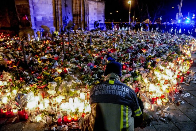Flowers are laid in front of the Johannis church near the Christmas Market in Magdeburg, Germany, Monday, December 23, 2024. (Photo by Ebrahim Noroozi/AP Photo)