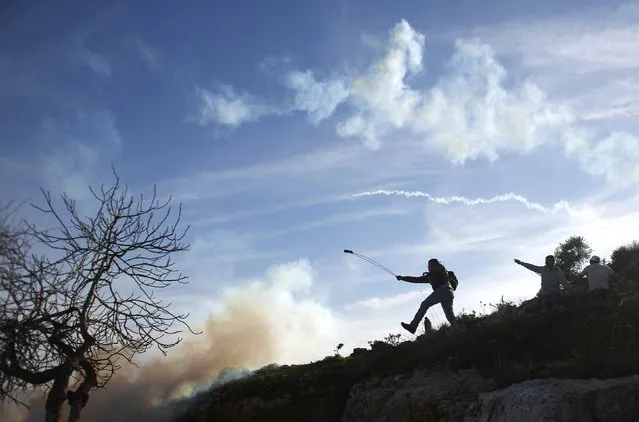 A Palestinian protester uses a slingshot to throw stones at Israeli troops during clashes near Israel's Ofer Prison, near the West Bank city of Ramallah January 23, 2015. (Photo by Mohamad Torokman/Reuters)