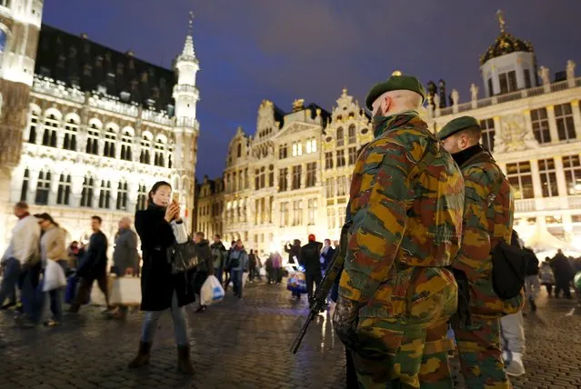 Belgian soldiers pose for a photograph as they patrol along “Winter Wonders”, a Christmas market on Brussels' Grand Place, Belgium, December 24, 2015, following tight security measures linked to the fatal attacks in Paris. (Photo by Francois Lenoir/Reuters)