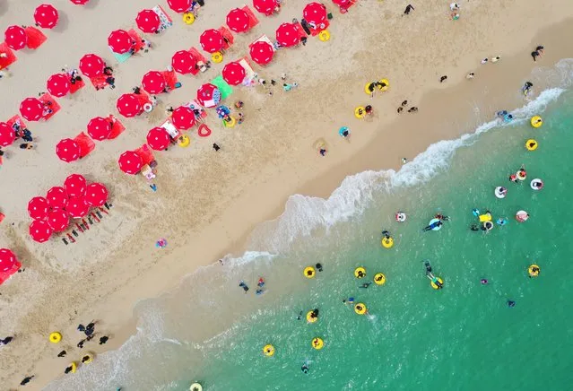 An aerial view of red beach parasols as people enjoy at Gyeongpo Beach in Gangneung, Gangwon Province, South Korea, 02 July 2023. (Photo by Yonhap/EPA)
