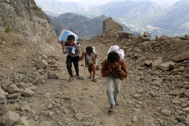 People carry foodstuff and goods as they transport them on a mountainous road to Yemen's southwestern war-torn city of Taiz December 26, 2015. (Photo by Reuters/Stringer)