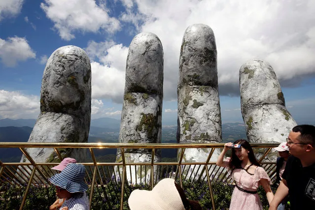 Tourists walk past giant hand structure on Gold Bridge on Ba Na hill near Danang city, Vietnam on August 1, 2018. (Photo by Reuters/Kham)
