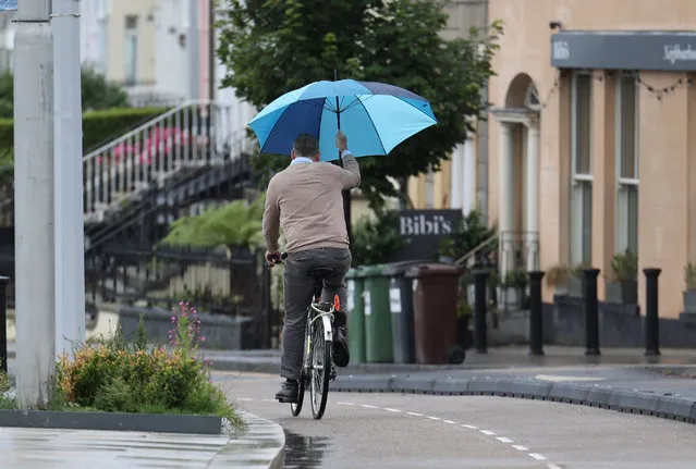 A cyclist takes shelter from the elements while in transit in Sandycove, Dublin, Ireland on July 18, 2023. (Photo by Nick Bradshaw/The Irish Times)
