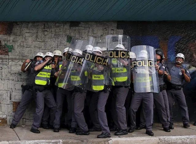 Riot police protect themselves behind shields as object are thrown at them by demonstrators during a protest against fare hikes for city buses in Sao Paulo, Brazil, January 8, 2016. (Photo by Nacho Doce/Reuters)