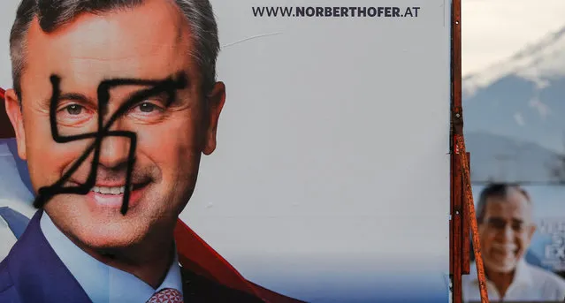 A vandalised poster of Austrian presidential candidate Norbert Hofer is seen next to a poster of rival Alexander Van der Bellen, in Innsbruck, Austria December 1, 2016. (Photo by Dominic Ebenbichler/Reuters)