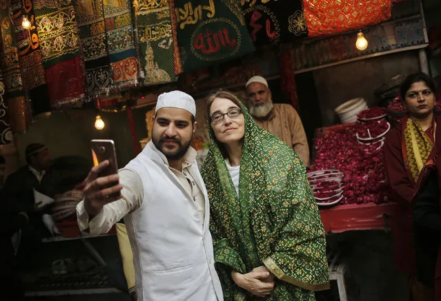 A Muslim cleric takes a selfie with Sarah Sewall (C), U.S. Under Secretary for Civilian Security, Democracy and Human Rights, during her visit to the shrine of Sufi Saint Nizamuddin Auliya in New Delhi, India, January 14, 2016. (Photo by Anindito Mukherjee/Reuters)
