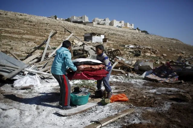 Palestinian boys carry their belongings after the Israeli army demolished their shanty, that their family lives in, near the Israeli West Bank settlement of Maale Adumim, near Jerusalem January 6, 2016. (Photo by Mohamad Torokman/Reuters)