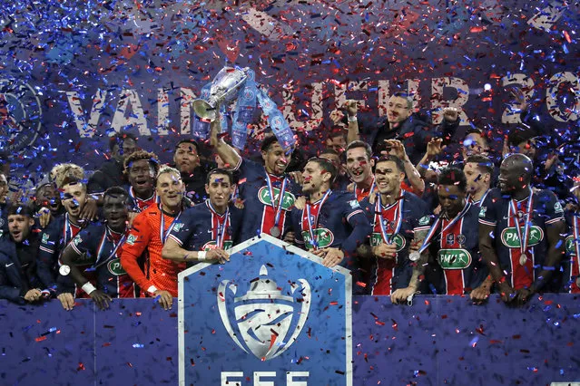 PSG players pose with the trophy after winning the French Cup final soccer match between Paris Saint Germain and Monaco at the Stade de France stadium, in Saint Denis, north of Paris, Wednesday, May 19, 2021. (Photo by Christophe Ena/AP Photo)