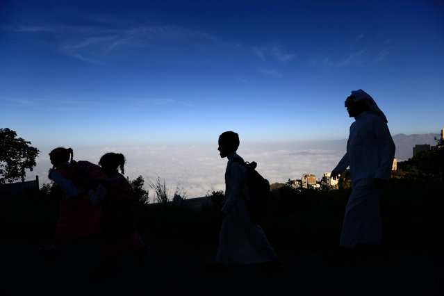Saudi man Yazid al-Fefi walks with his children as they make their way to their schools through Fifa Mountain, in Jazan, south of Saudi Arabia, December 15, 2016. (Photo by Mohamed Al Hwaity/Reuters)