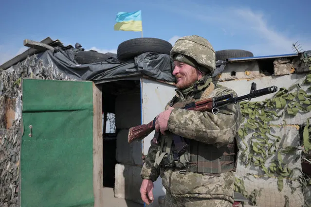 An Ukrainian serviceman patrols at the checkpoint in the village of Shyrokyne near Mariupol, the last large city in eastern Ukraine controlled by Kiev on April 26, 2021. With weapons in hand and their backs to the sea, Ukrainian soldiers in the war-torn east said the clashes continue despite Moscow's announcement of its troops withdrawal from Ukraine's borders. (Photo by Aleksey Filippov/AFP Photo)
