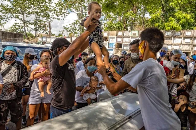 A baby is carried over the coffin of Lilibeth Valdez as part of a ritual during her funeral on June 4, 2021 in Quezon city, Metro Manila, Philippines. (Photo by Ezra Acayan/Getty Images)