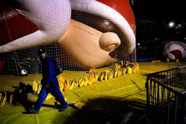 Workers prepare giant balloons on Wednesday night for Thursday's 87th annual Macy's Thanksgiving Day Parade in New York City. (Photo by John Moore/Getty Images)