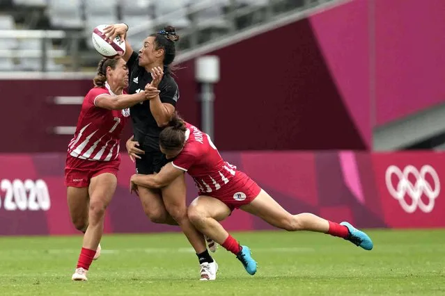 New Zealand's Theresa Fitzpatrick, center, gets tackled by Russian Olympic Committee's Kristina Seredina, left, and Russian Olympic Committee's Marina Kukina in their women's rugby sevens quarterfinal match at the 2020 Summer Olympics, Friday, July 30, 2021 in Tokyo, Japan. (Photo by Shuji Kajiyama/AP Photo)