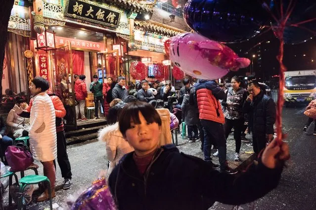 People wait their turn outside a restaurant for dinner during Lunar New Year celebrations in Beijing on February 11, 2016. Millions of Chinese are celebrating the “Spring Festival”, the most important holiday on the Chinese calendar, which this year marks the beginning of the Year of the Monkey. (Photo by Fred Dufour/AFP Photo)