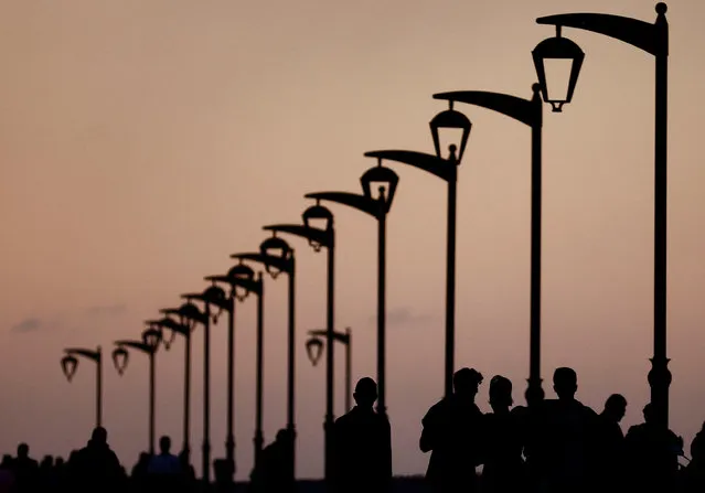 People walk at Beirut's seaside corniche during sunset, Lebanon on November 28, 2023. (Photo by Yara Nardi/Reuters)