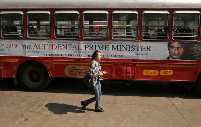 A woman walks past a bus featuring an advertising of the upcoming Bollywood film “The Accidental Prime Minister” in Mumbai, January, 5, 2019. (Photo by Francis Mascarenhas/Reuters)