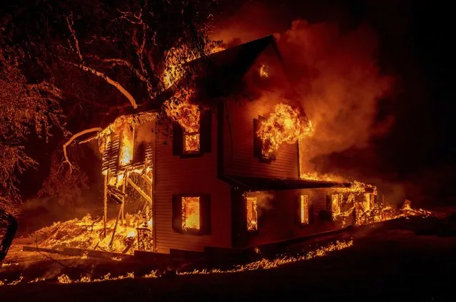 A home burns on Jeters Road as the Dixie fire jumps Highway 395 south of Janesville, Calif., on Monday, August 16, 2021. Critical fire weather throughout the region threatens to spread multiple wildfires burning in Northern California. (Photo by Ethan Swope/AP Photo)
