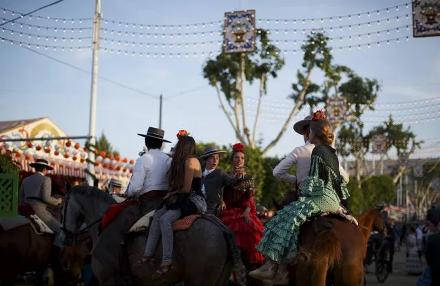 Riders wearing Andalusian outfits attend the traditional Feria de Abril (April fair) in the Andalusian capital of Seville, southern Spain, April 22, 2015. (Photo by Marcelo del Pozo/Reuters)