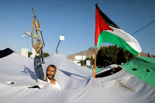 A protester holds a gun, as he takes part in a demonstration in solidarity with Palestinians in the Gaza Strip, amid the ongoing conflict between Israel and the Palestinian Islamist group Hamas, in Sanaa, Yemen on December 8, 2023. (Photo by Khaled Abdullah/Reuters)