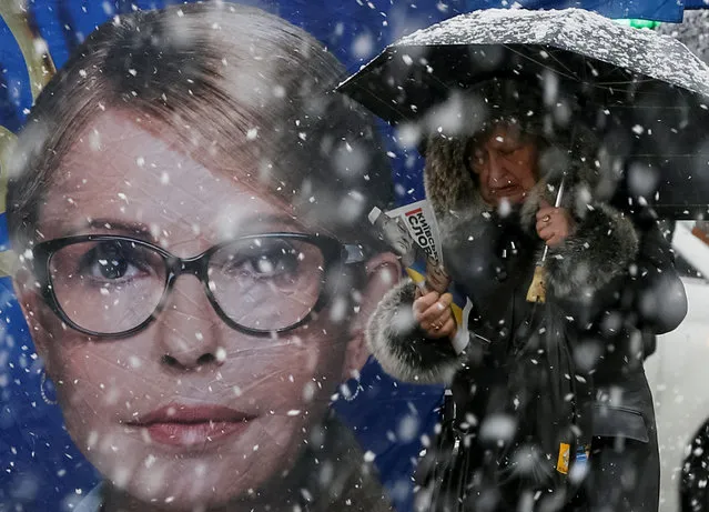 A woman passes by an election campaign tent of leader of opposition Batkivshchyna party and presidential candidate Yulia Tymoshenko, during snowfall in central Kiev, Ukraine on March 27, 2019. (Photo by Gleb Garanich/Reuters)