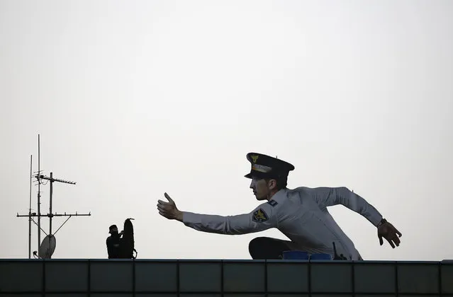 A sniper from Special Weapons and Tactics (SWAT) team stands next to an advertisement of South Korean police station after an anti-terror drill in Seoul, South Korea, March 15, 2016. (Photo by Kim Hong-Ji/Reuters)