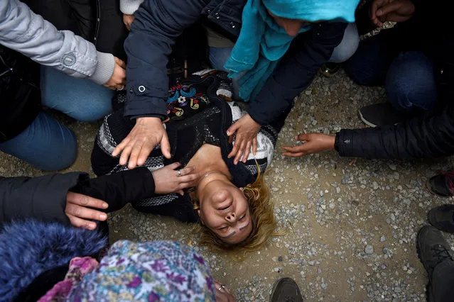 A woman collapses as migrants and refugees, who say that they seek to travel onward to northern Europe, scuffle with riot police officers near the town of Diavata in northern Greece, April 5, 2019. (Photo by Alexandros Avramidis/Reuters)