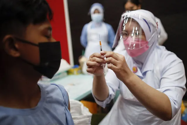 A nurse prepares to administer a dose of Pfizer COVID-19 vaccine during a vaccination program for teenagers under 18-year-old in Shah Alam, outside Kuala Lumpur, Malaysia, 06 October 2021. The Malaysian government is targeting at least 60 percent of the country's teenager population to receive at least one dose of vaccine by November this year, with the aim of having 80 percent of teenagers fully vaccinated by next January. (Photo by Fazry Ismail/EPA/EFE)
